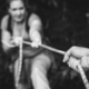 Blurred image of a hand holding a rope to support a woman climbing up