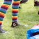 legs wearing rainbow socks and black Converse sneakers