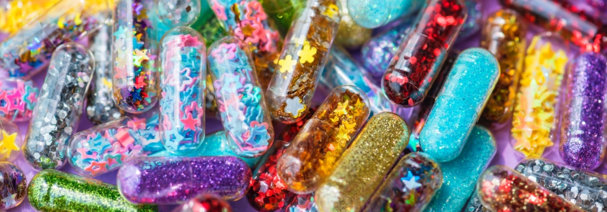 capsules filled with rainbow colours, glitter, and stars