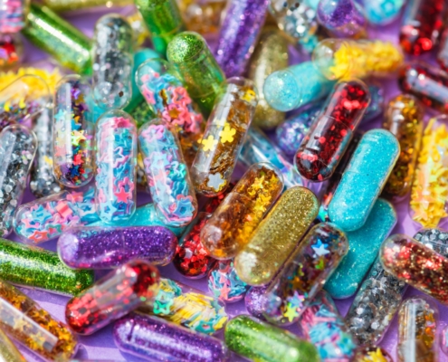 capsules filled with rainbow colours, glitter, and stars