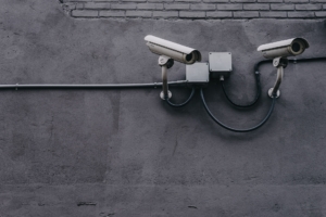 Security cameras attached to a grey cement wall