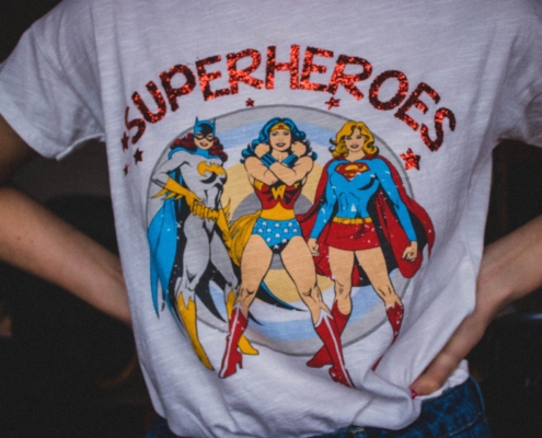 Person wearing t-shirt with women superheroes on the front