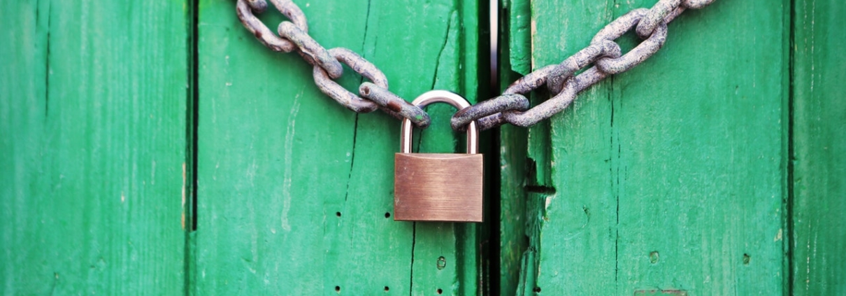 Padlock and chain on green door