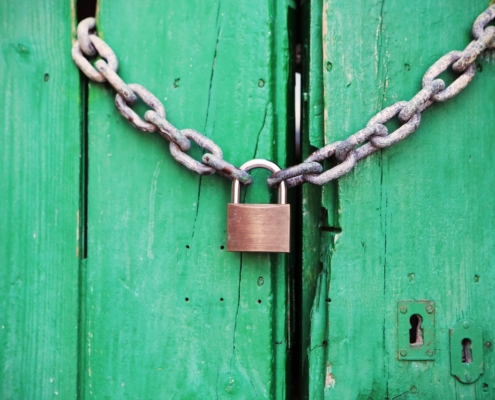 Padlock and chain on green door