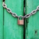 Padlock and chain on green door