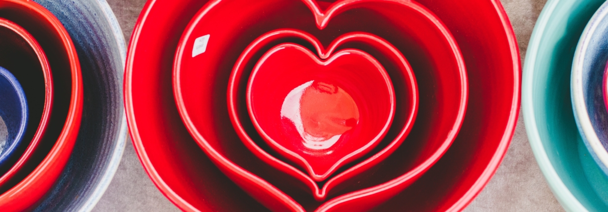 red heart-shaped ceramic bowls of different sizes stacked one inside the other