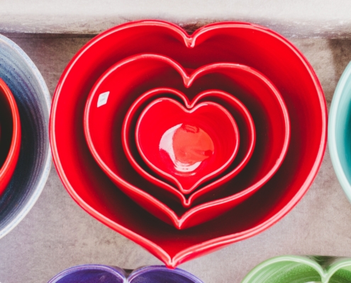 red heart-shaped ceramic bowls of different sizes stacked one inside the other