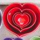 red heart-shaped ceramic bowls of different sizes stacked one inside the other