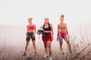 three fashionable and diverse women wearing gym clothes outdoors