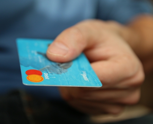 Hand holding a blue credit card