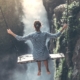 Woman sitting on a swing over a valley in the mountains