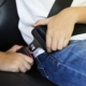 Person fastening a seatbelt