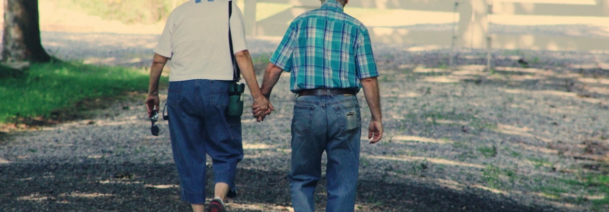 Elderly man and woman walking and holding hands