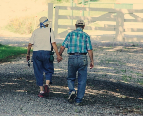 Elderly man and woman walking and holding hands