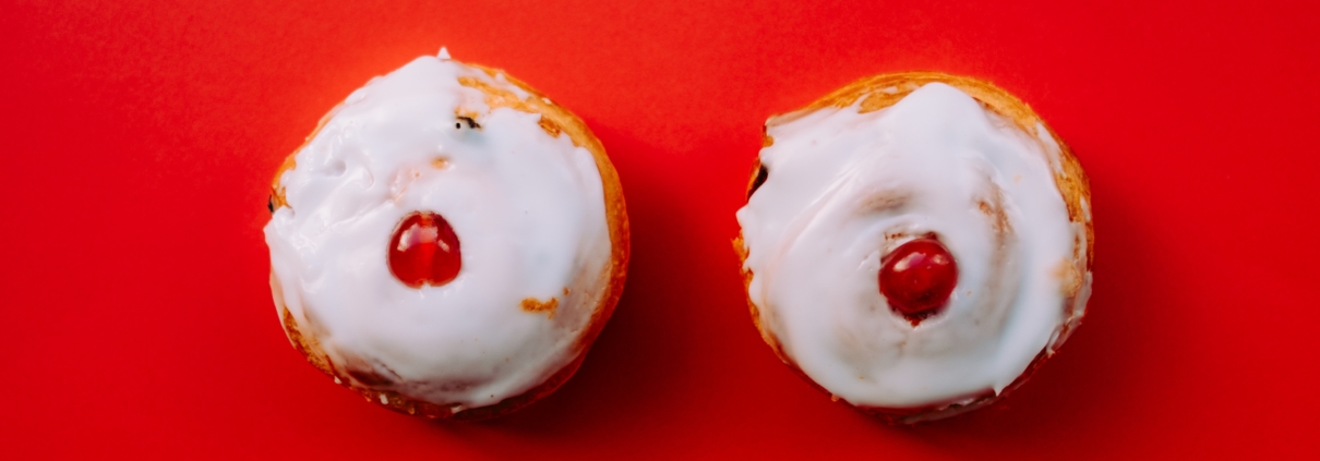 two white frosted cupcakes with cherry toppings