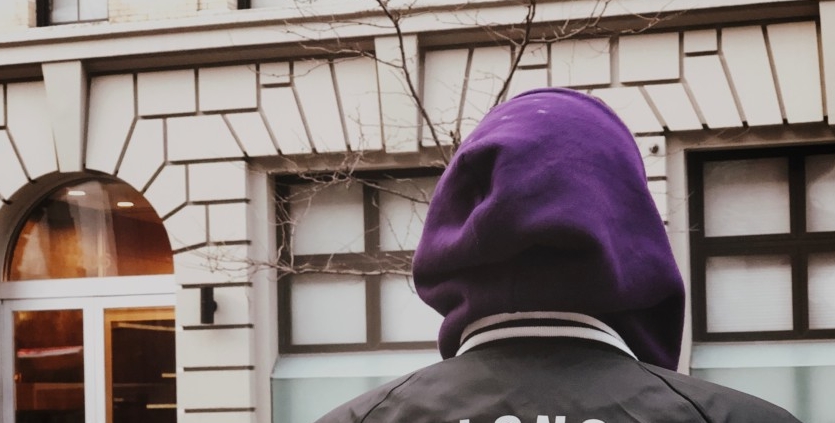 person in hoodie outside building